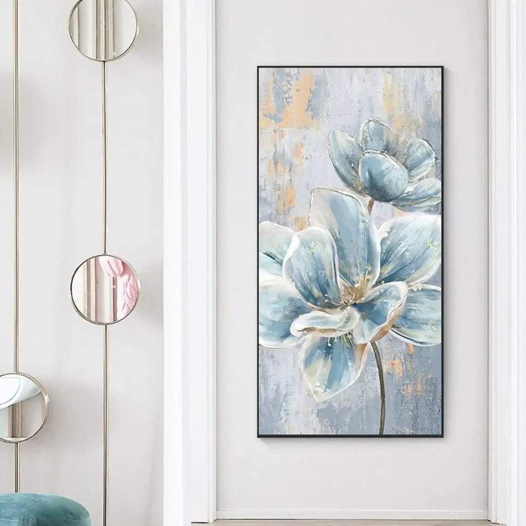 Blue and white floral wall art, delicate blossoms in a snowy setting with gold accents in a black frame in a hallway