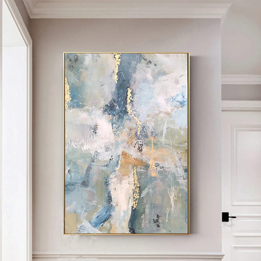 Abstract blue and gold painting wall art, dynamic splashes with gold leaf details in a thin gold frame on a neutral wall
