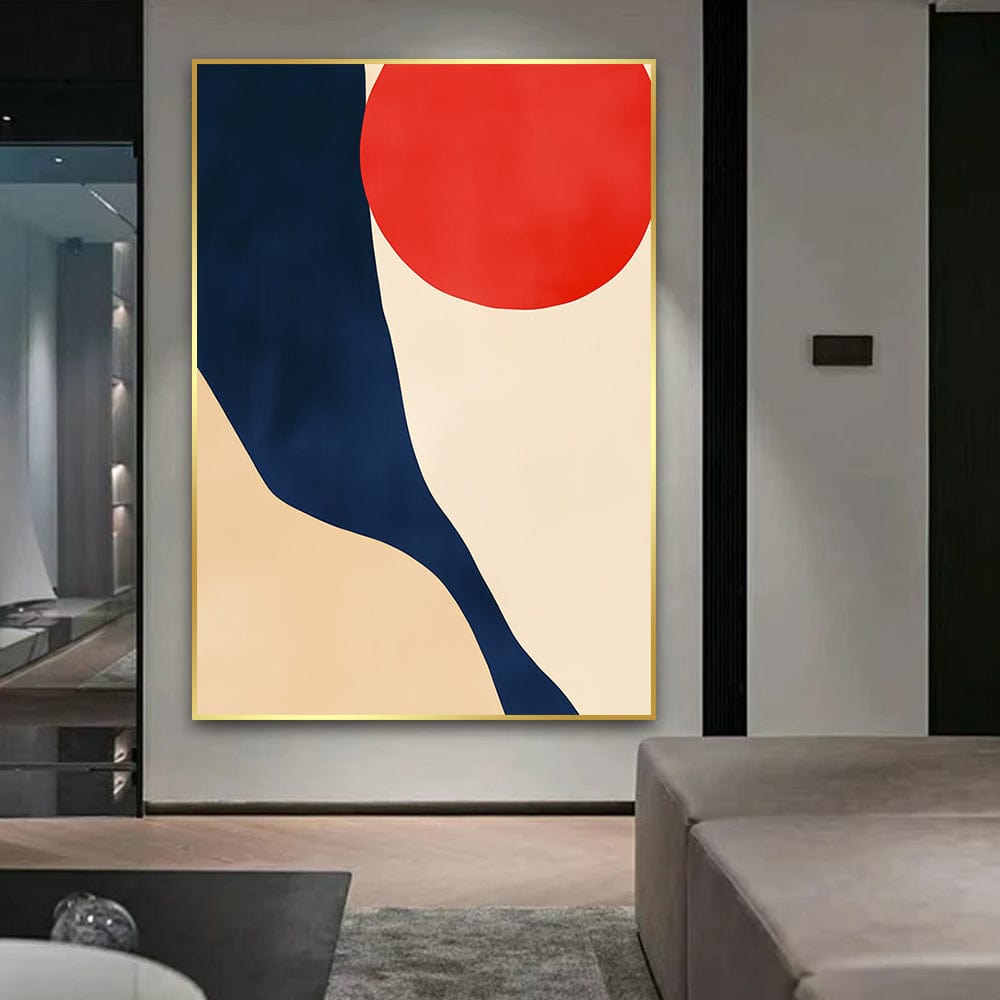 Abstract red orb and navy shape wall art with beige tones in a thin gold frame hanging in a modern living room
