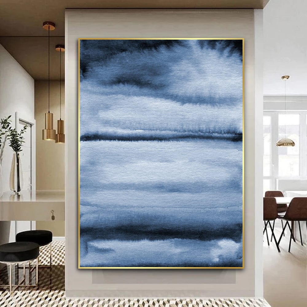Abstract blue watercolor wall art, dark and light blue wash landscape painting in a thin gold frame hanging in a hallway