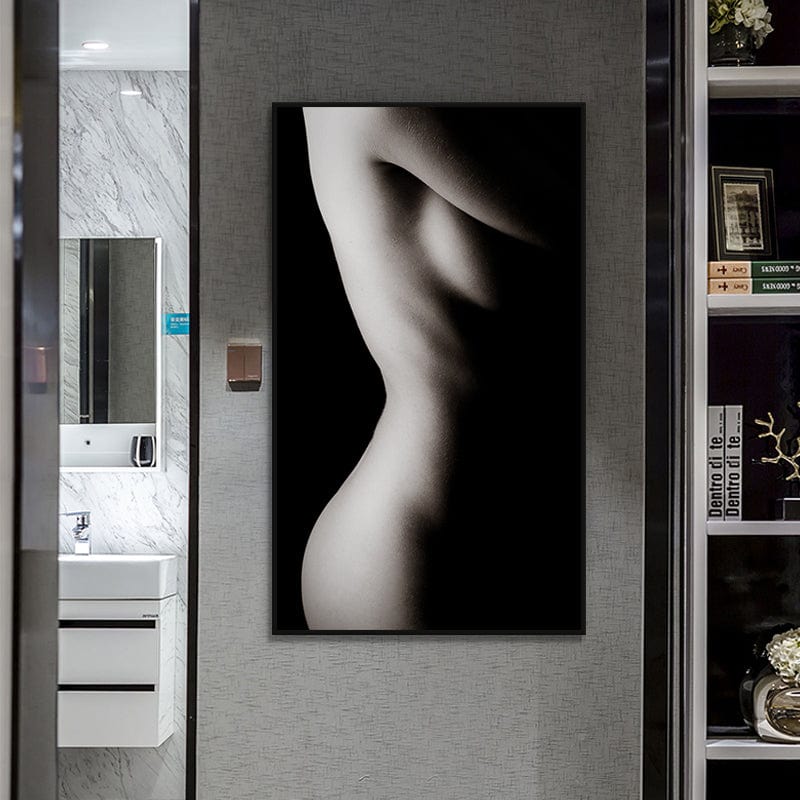 Nude female figure wall art, black and white silhouette of a woman's torso in a black frame in a hallway