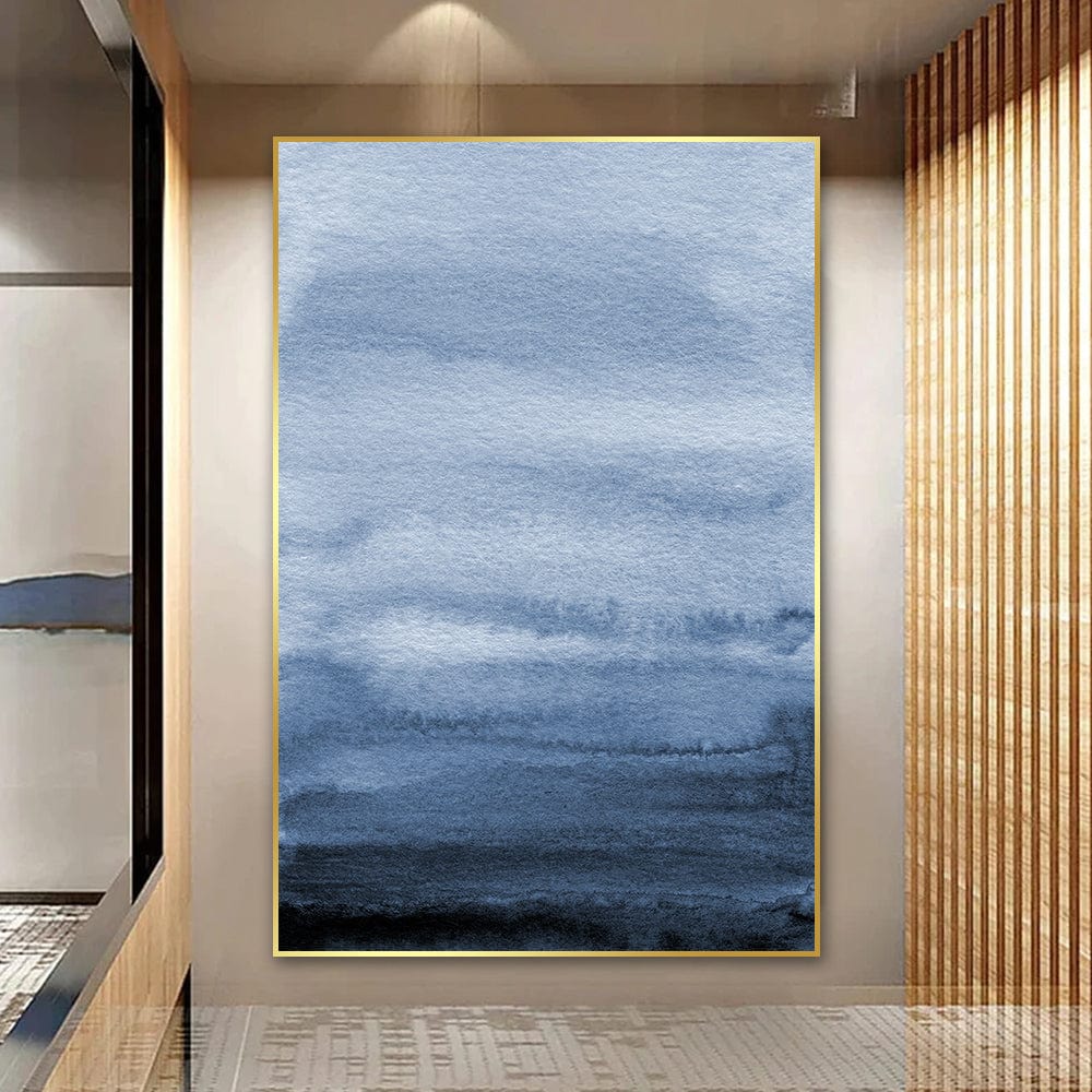 Blue ocean landscape painting wall art, abstract watercolor washes in navy and white with a thin gold frame in a hallway