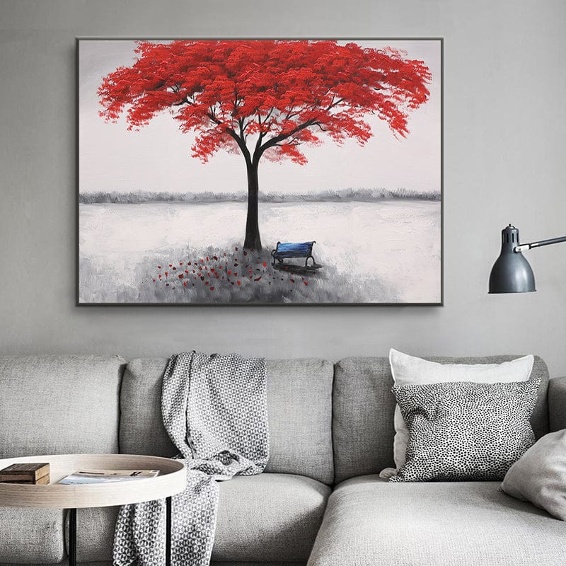 Red tree landscape wall art, vibrant red tree with a blue bench in a snowy field hanging above a grey sofa