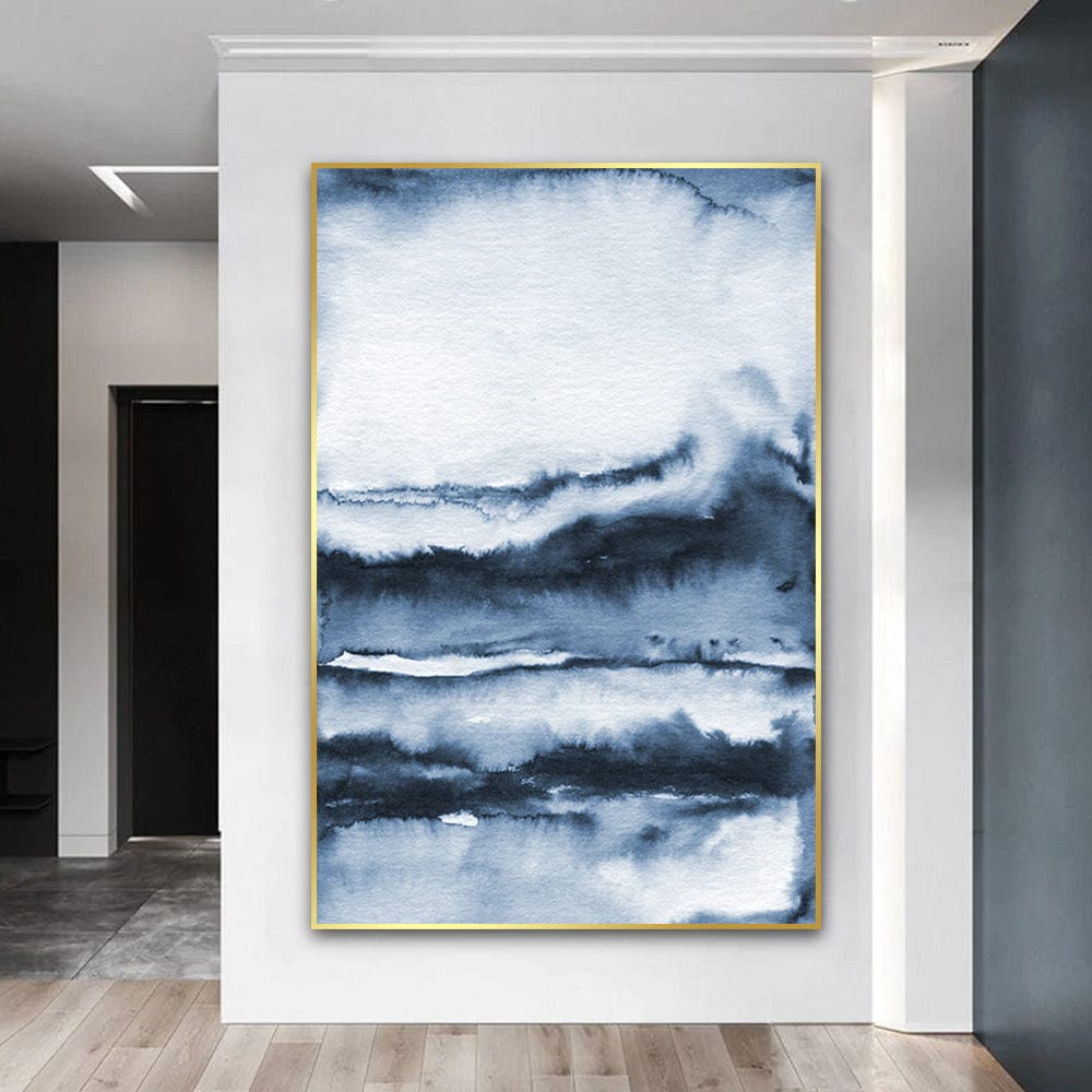 Abstract blue watercolor landscape wall art, layered dark blue and white wash tones in a gold frame on a white wall