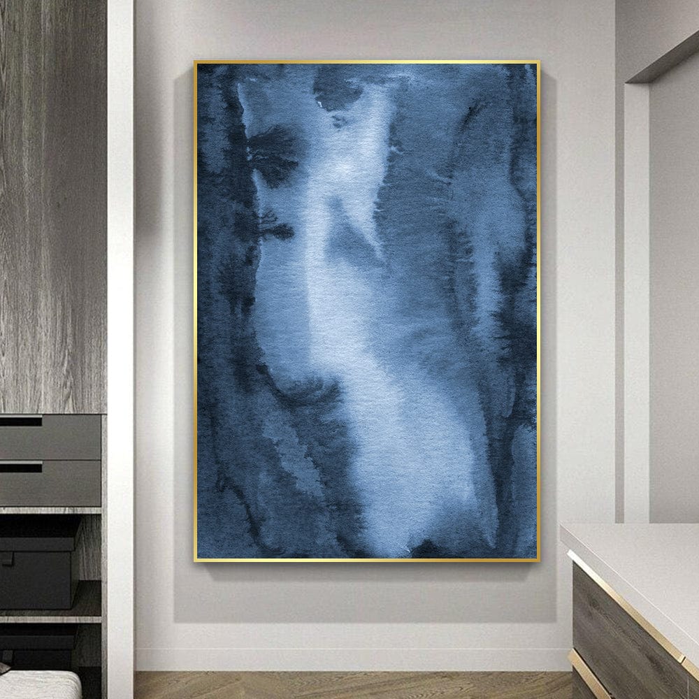 Abstract blue watercolor portrait wall art with indigo washes in a thin gold frame hanging on a white wall