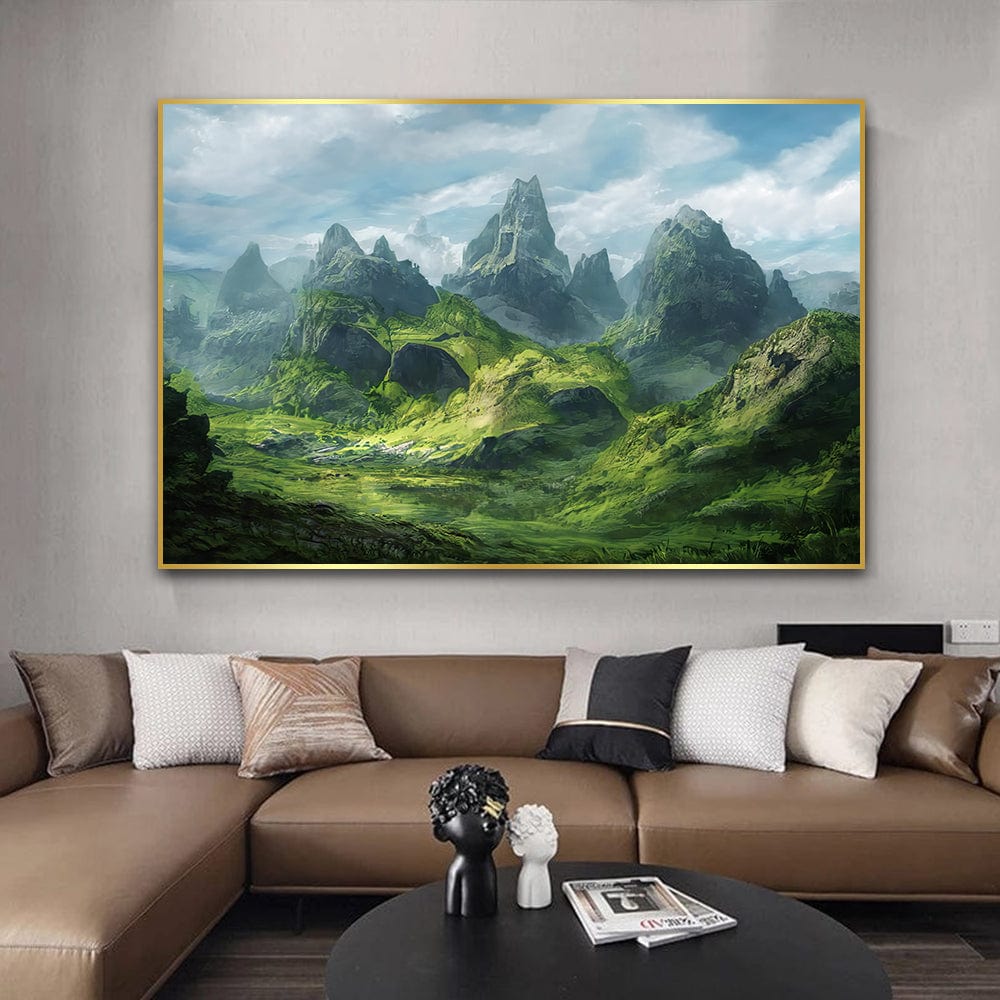 Green valley landscape wall art, majestic mountains under a cloudy sky in a thin gold frame above a brown leather sofa