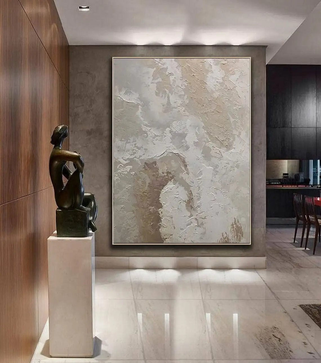 Abstract neutral texture wall art, beige and cream strokes hanging in a hallway with a sculpture on a pedestal