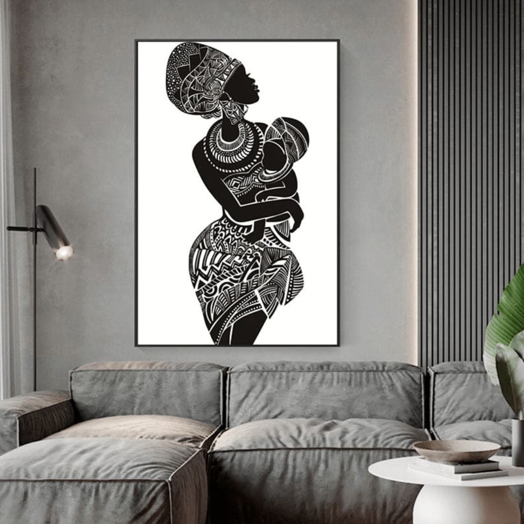 African mother and child wall art, black silhouette woman in a patterned head wrap cradling a baby, framed above a gray sofa