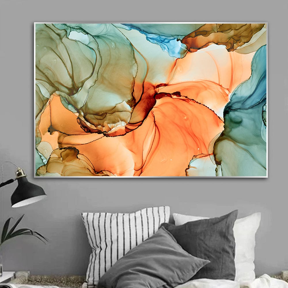 Abstract orange and green landscape wall art, fluid ink painting hanging above a bed with striped pillows