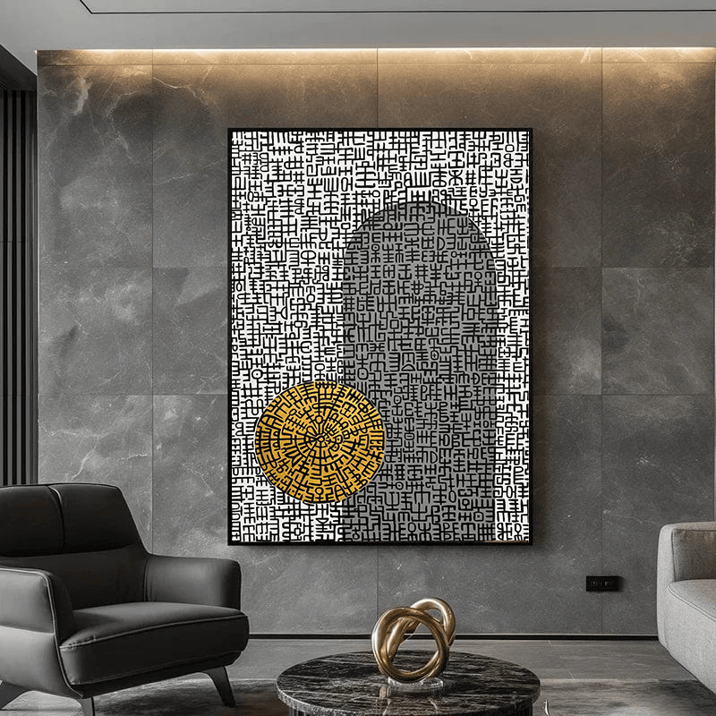 Abstract symbol wall art with black and white patterns and a gold circle hanging on a grey wall above a marble table