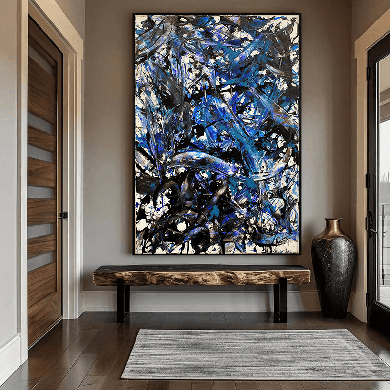 Abstract blue and black gesture painting wall art in a black frame above a wooden bench in an entryway hallway