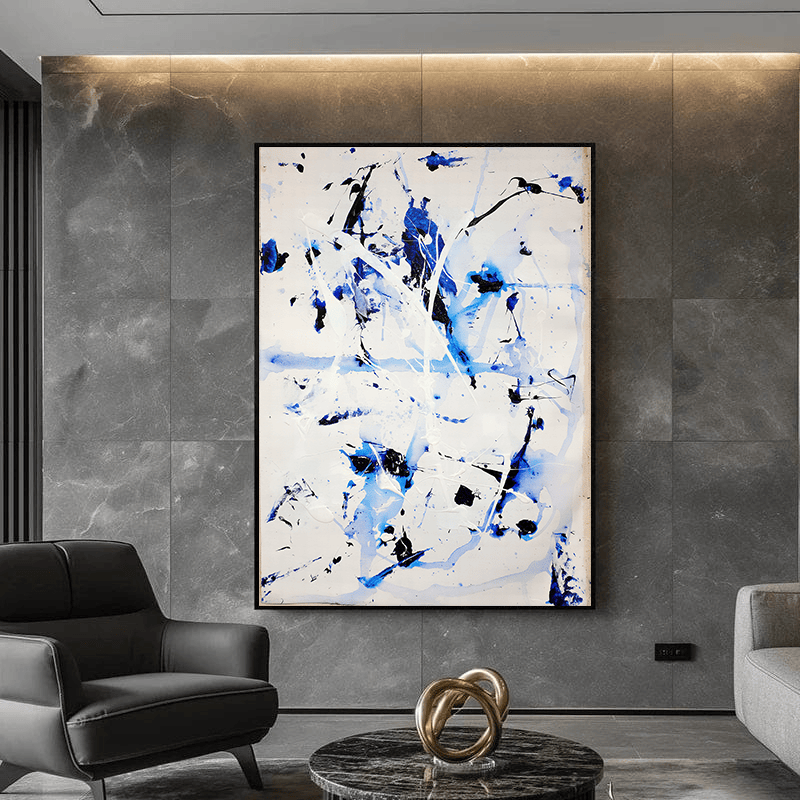 Blue and black abstract expressionist wall art, fluid gestures and strokes in a black frame above a sofa