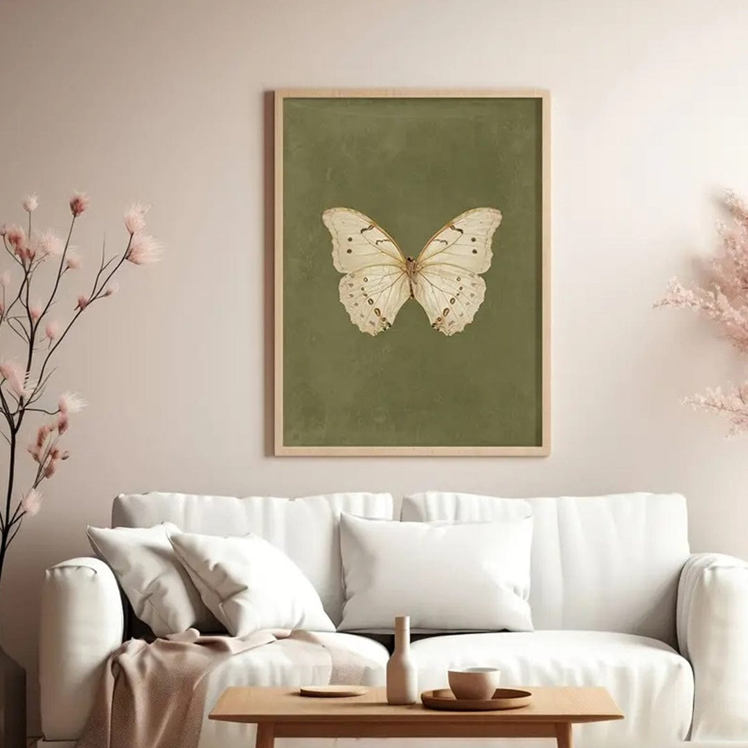 White Butterfly wall art, pale insect with gold patterns on olive in wood frame above sofa