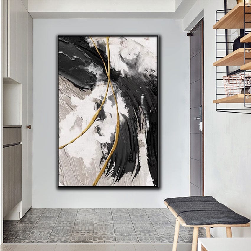 Abstract black and white wall art, textured brushstrokes with delicate gold lines in a black frame hanging in an entryway