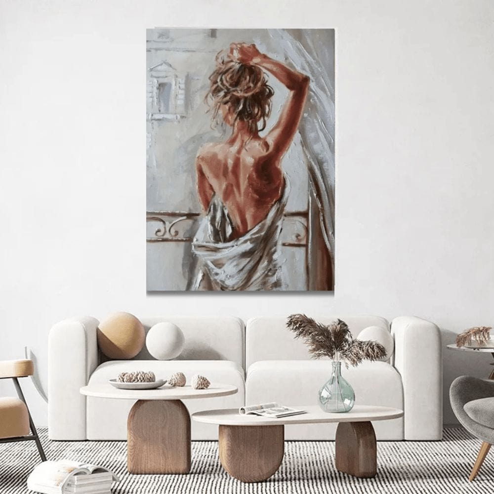 Woman painting wall art, bare back of a woman holding her hair at a window, unframed above a white sofa in a living room