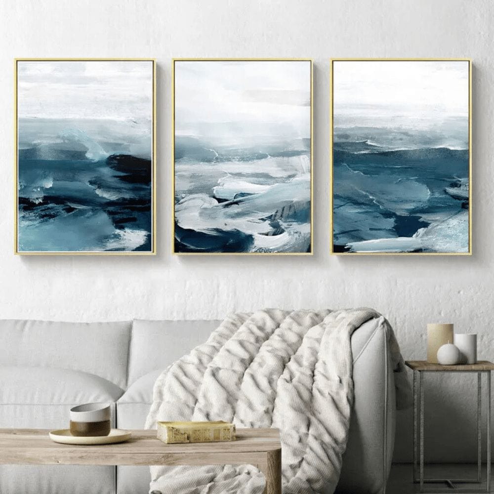 Before the Storm wall art, three piece blue Arctic sea landscape painting hanging above a white sofa