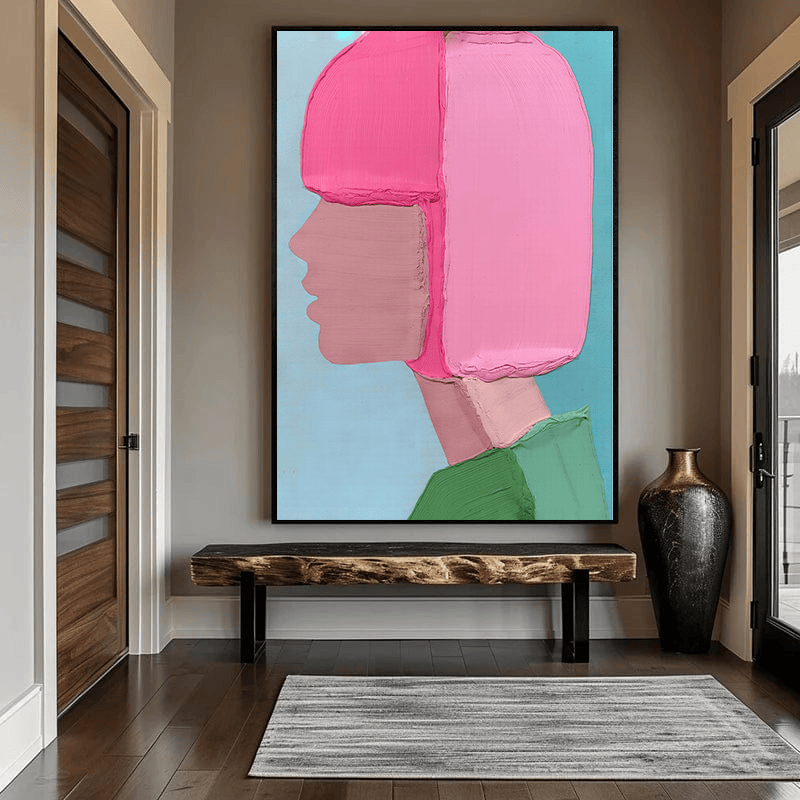 Pink abstract woman wall art, minimalist profile of a woman with a pink bob and green top on pale blue, above an entry bench