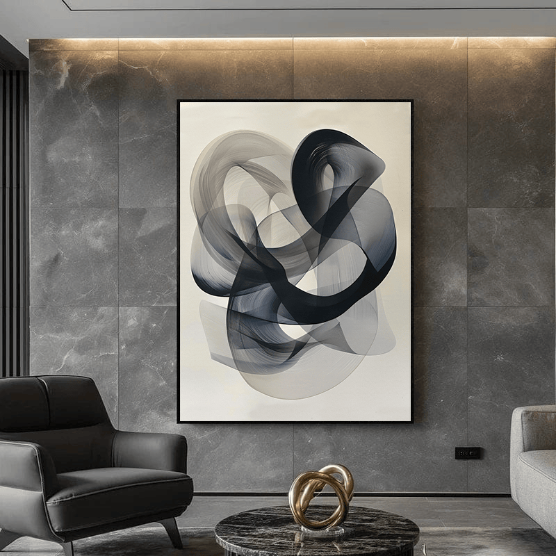 Abstract black and grey lines wall art, translucent sweeping forms in a black frame above an armchair