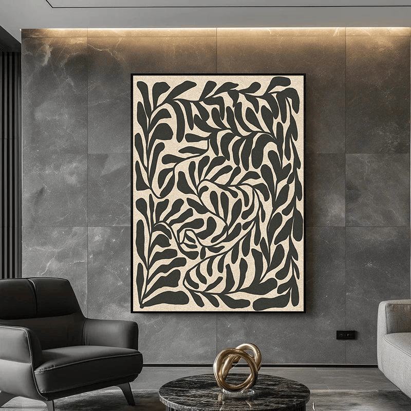 Black and beige botanical wall art painting in a black frame on a gray stone tile wall