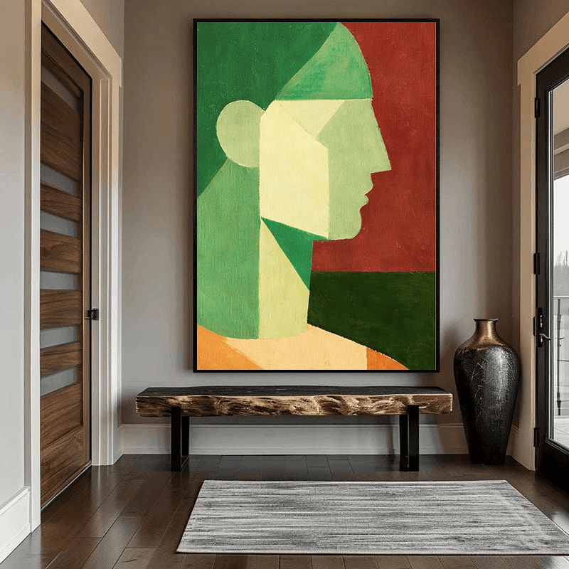 Abstract woman portrait wall art, geometric side profile in green, cream, and red tones hanging in an entryway