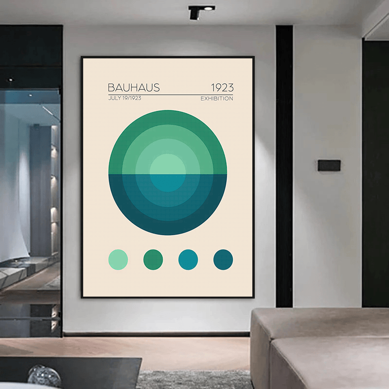 Green geometric Bauhaus wall art print in a black frame mounted on a white wall above a sofa