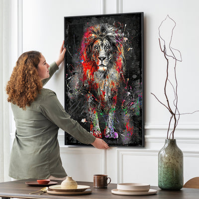 Woman hanging a colorful lion painting on a wall above a dining table.