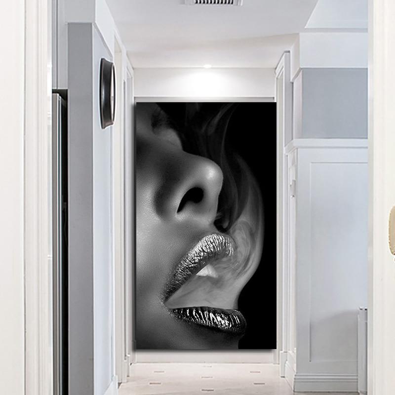 Black and white woman wall art, close-up of a female face with silver lips exhaling smoke, hung at the end of a white hallway