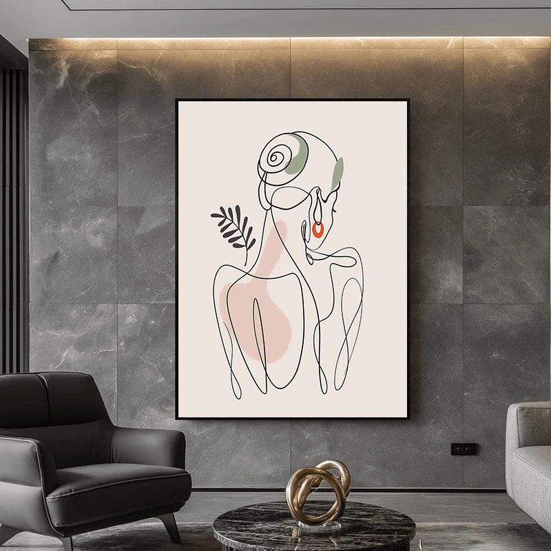 Black and white abstract woman portrait wall art in a black frame on a dark stone wall above a sofa in a living room