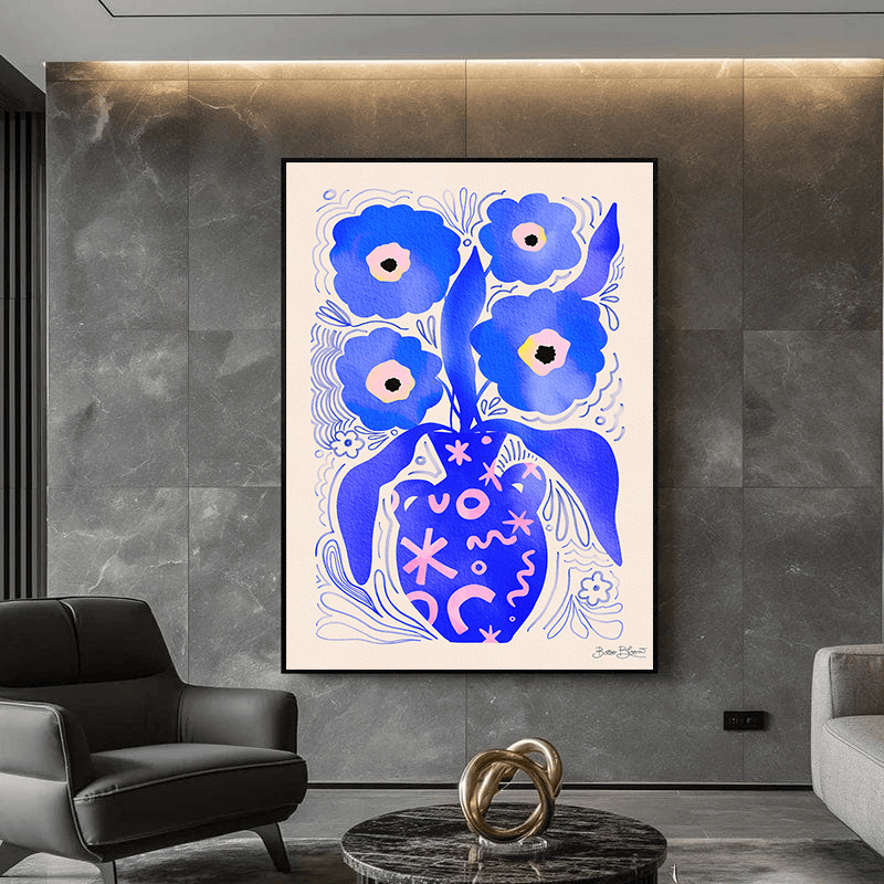 Blue floral botanical wall art in a black frame above a grey armchair and marble coffee table in a modern living room