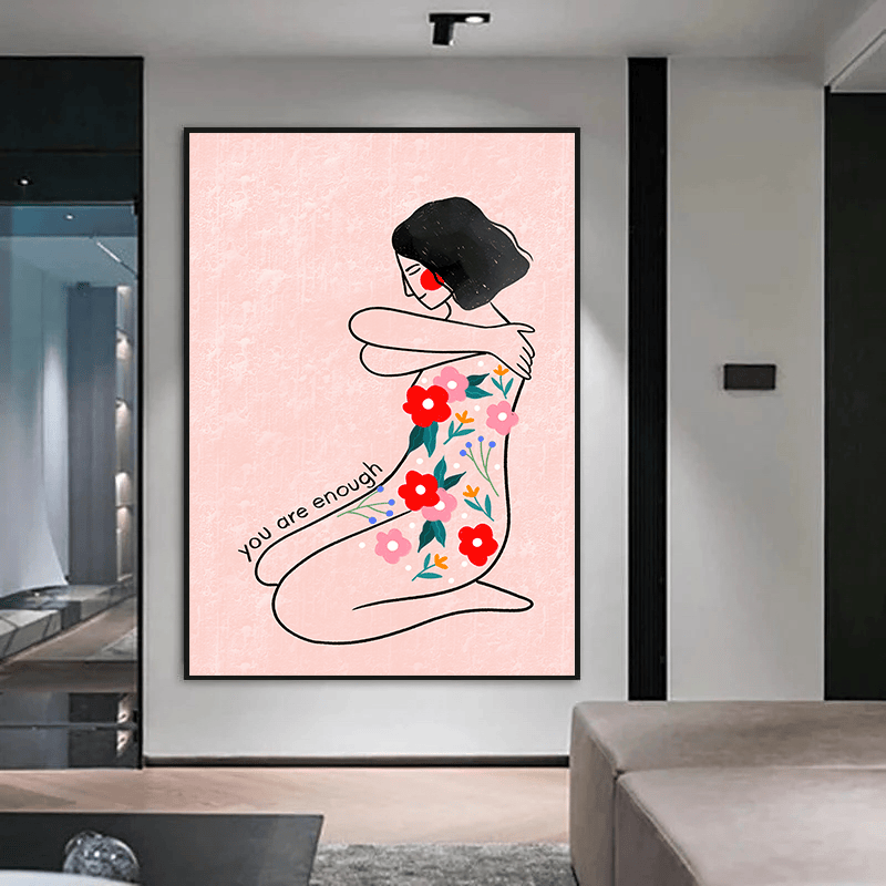 Black framed woman portrait wall art hanging above a sofa in a modern living room