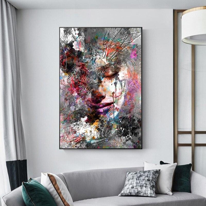 Colorful abstract woman wall art, mixed media female face with closed eyes in red, pink, teal and gray splatter, above a sofa
